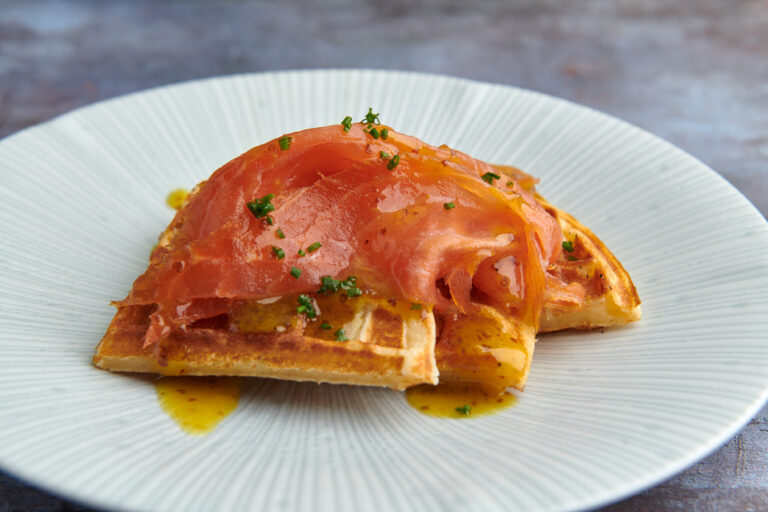 Smoked salmon on a bed of malted sourdough waffles with a sweet honey mustard sauce